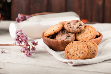 Chocolate chip cookies with milk on burlap and rustic wooden table