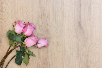 Wooden background with pink roses