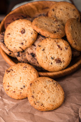 Chocolate chip cookies with milk on burlap and rustic wooden table