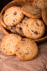 Chocolate chip cookies with milk on burlap and rustic wooden table