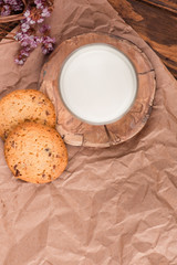 Chocolate chip cookies with milk on burlap and rustic wooden table