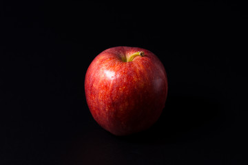 Red apple isolated on a black background.