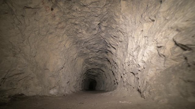 Speleology artificial cave dark tunnel excavation underground. Old adit for the extraction of metal and rocks