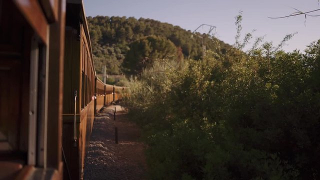 Old vintage wooden Soller Train in Mallorca driving through wilderness on a sunny day