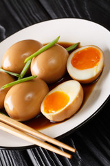 Recipe of delicious japanese nitamago eggs close-up in a plate. vertical