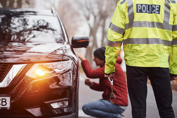 Police officer in green uniform caught automobile theft on the road