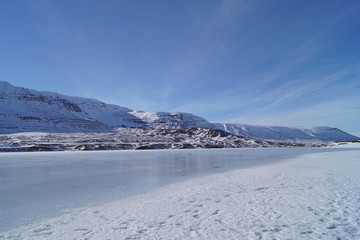Fototapeta na wymiar winter landscape with snow covered mountains and a frozen sea in Iceland