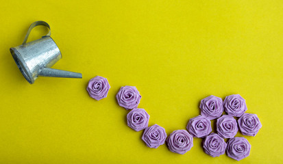 Old vintage metal watering can isolated on yellow background. © Sofya