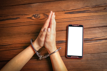 phone with hands addiction on a wooden background