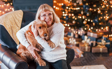 Grandmother indoors with dog in christmas decorated room