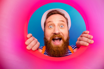 Close up photo surprised shocked sailor man watch pink round ring rescue buoy impressed scream wow omg wear white style stylish trendy nautical vest headwear isolated blue color background - obrazy, fototapety, plakaty