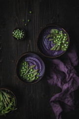 Purple vegetable spring soup with red cabbage, asparagus and green pea.