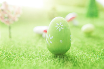 Green Easter egg outside in grass with evening sun from behind