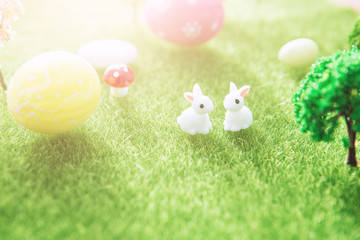 Spring meadow with two white rabbit and easter eggs. Fairy tale