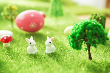 Easter rabbits on a green grass with Easter eggs in Dreamland or fairy world.