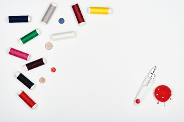 Colored threads and sewing accessories isolated on white.