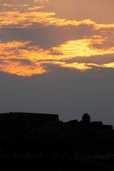 Silhouette of ancient Bahrain Fort watch tower during sunset