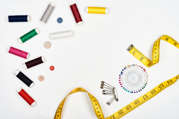 Sewing supplies and needlework accessories on a white surface. Top view.