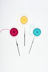 Colorful threads and crochet hooks isolated on white.