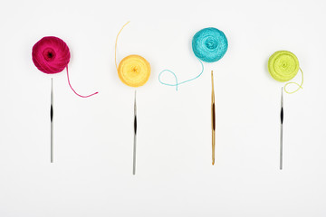 Composition with colorful threads and crochet hooks. White background. Top view.