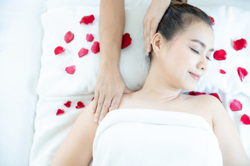 Obraz na płótnie Canvas Muscle Relaxing Massage spa. A woman sleeping on bed and receiving shoulder and neck massage. Massaging patients neck. Space for text.