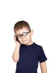  little funny Caucasian boy in glasses with occlusive eye dressing talking by mobile phone and smiling