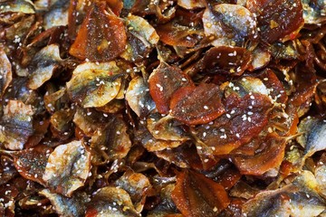 Sweet dried yellowstripe scad dry in light of sun for preservation. thai street food market