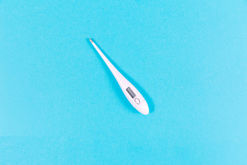 Medical digital white thermometer on blue bckground.