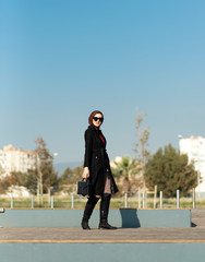 Modern young muslim woman is walking in the park