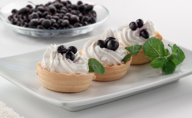 Homemade tartlets with cream cheese and fresh berries - currants and mint