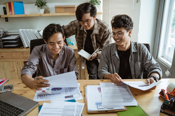 three young asian worker chatting about their product at work