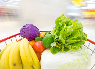 Supermarket interior, filled with the fruit and Vegetables of the shopping cart.
