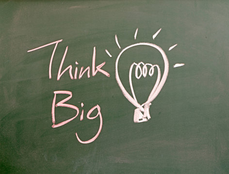 the word think big and light bulb drawn on a chalk board,business concept