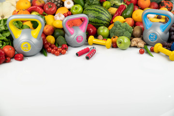 Fototapeta na wymiar Fitness concept. Healthy nutrition: fruits and vegetables. Equipment for fitness exercises: weighing machine and dumbells. White background.