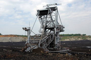 A huge bucket-wheel excavator digging coal on the open-pit mine. 