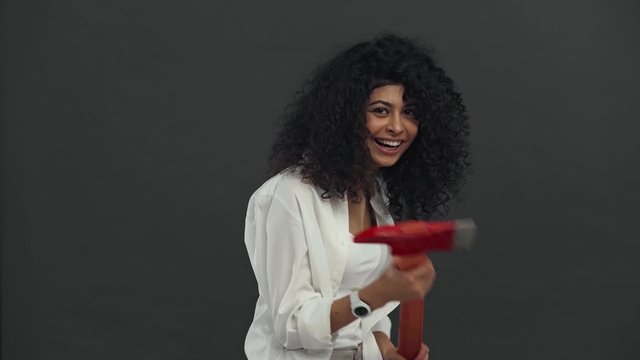 cheerful bi-racial woman holding ax isolated on black