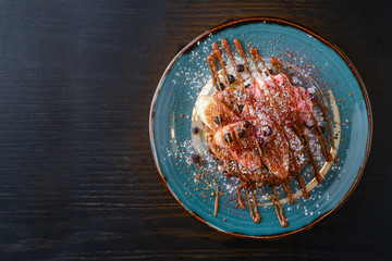 Sweet sandwich with peanut butter, caramel syrup, bananas and berries. Sweet delicious dessert with fruit.