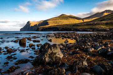 Glassy water near rocky shoreline