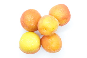 Ripe wet yellow plums located on a white background