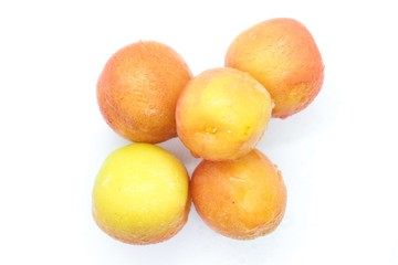 Ripe wet yellow plums located on a white background