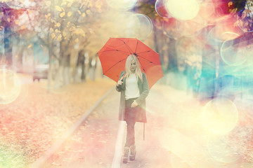autumn look, sunny day a young girl with an umbrella walks in a yellow park in October