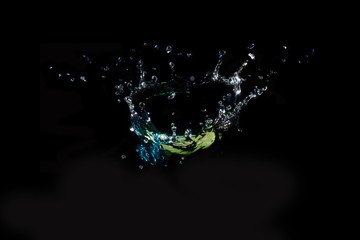 The object falls into the water until the sponge splits beautifully on a black background.