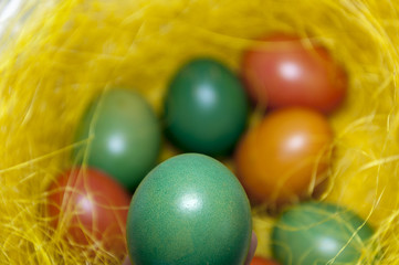 Fototapeta na wymiar Colored Easter eggs in basket. Selective focus.