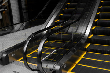 Empty escalators stairway with a yellow stripes.