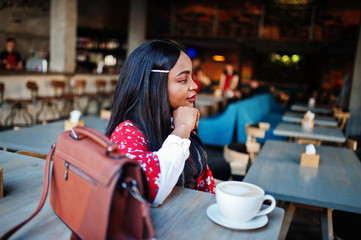 Сonfident young african american woman in smart casual wear at cafe.