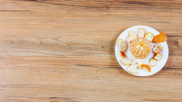  tangerine unlatches itself to a plate peeled and served on a plate when animation stops 4K