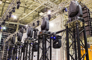 Moving head spotlight devices on a trusses. Installation of professional stage, sound and light...