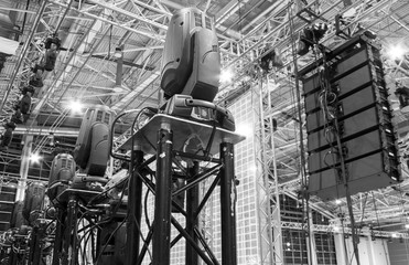 Moving head spotlight devices on a truss. Line array speakers. Installation of professional stage,...