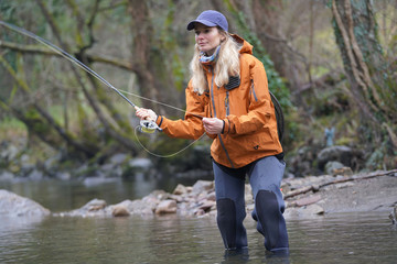 woman fly fishing in river