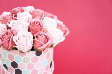 Flowers in bloom: A bouquet of pink and white roses in a round box on a pink background.